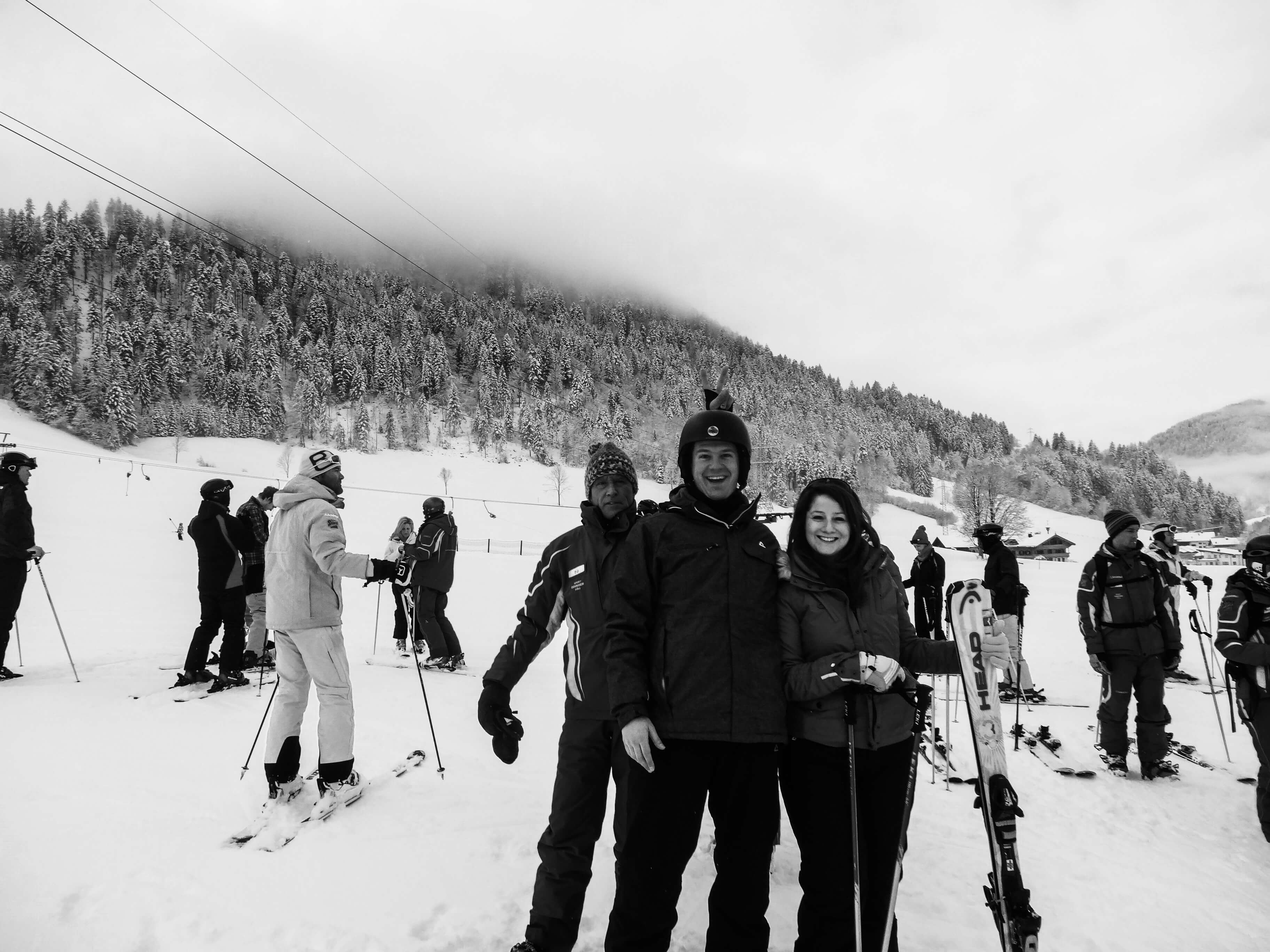 andi and me on skis with our ski instructor behind photo bombing