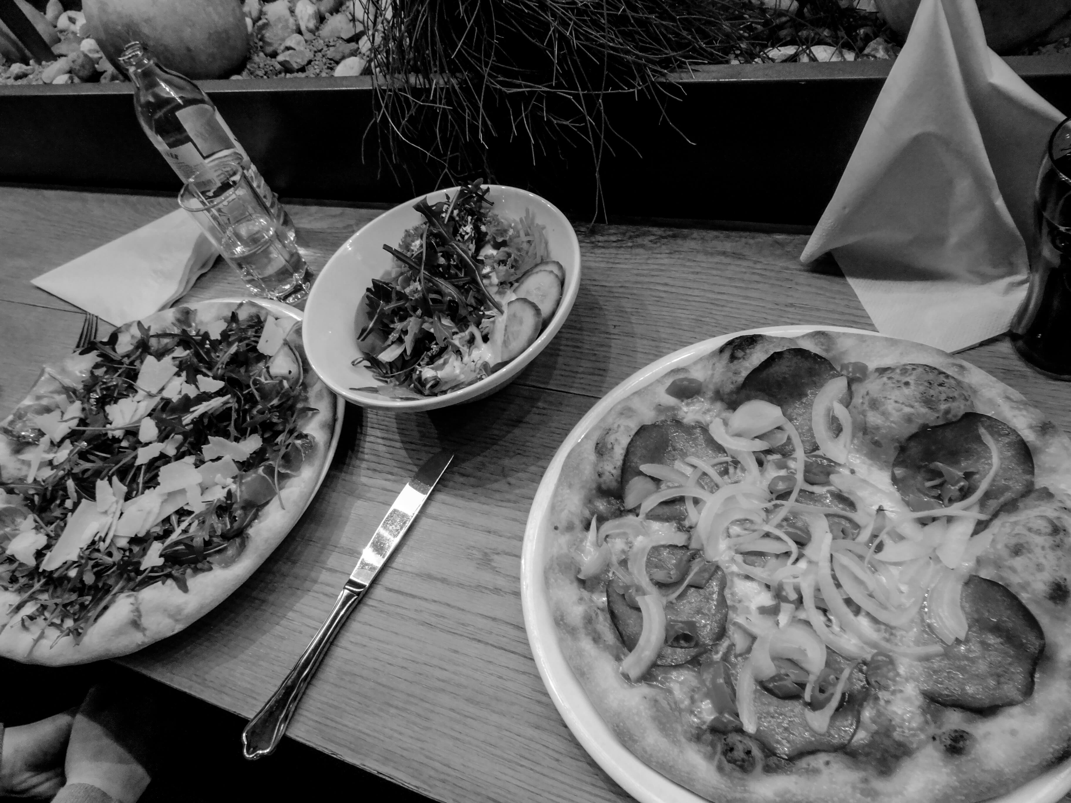 pizzas and salads on a table in an austrian restaurant in soll