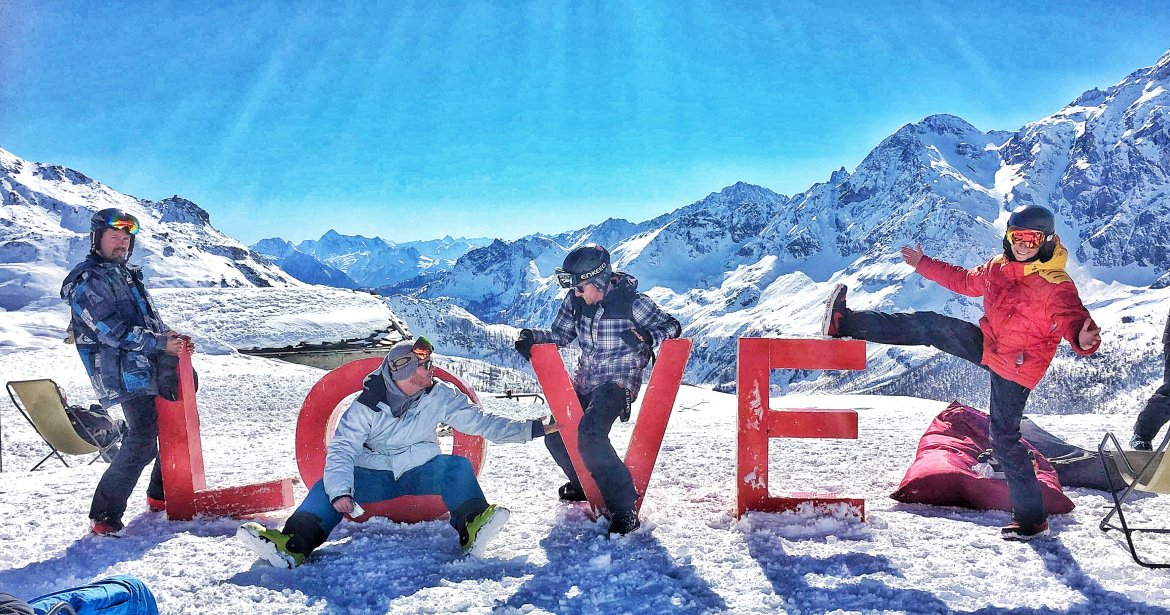 reasons-to-ski-for-happiness-four-skiers-on-sculpture-saying-love-in-the-mountains-surrounding-cervinia-italy
