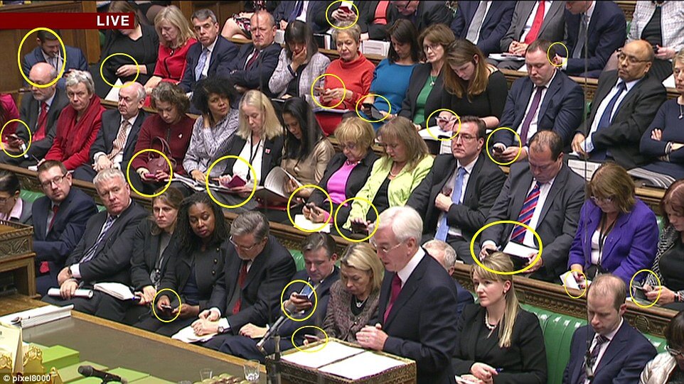 politicians in parliament on their smartphones rather than listening to the speaker