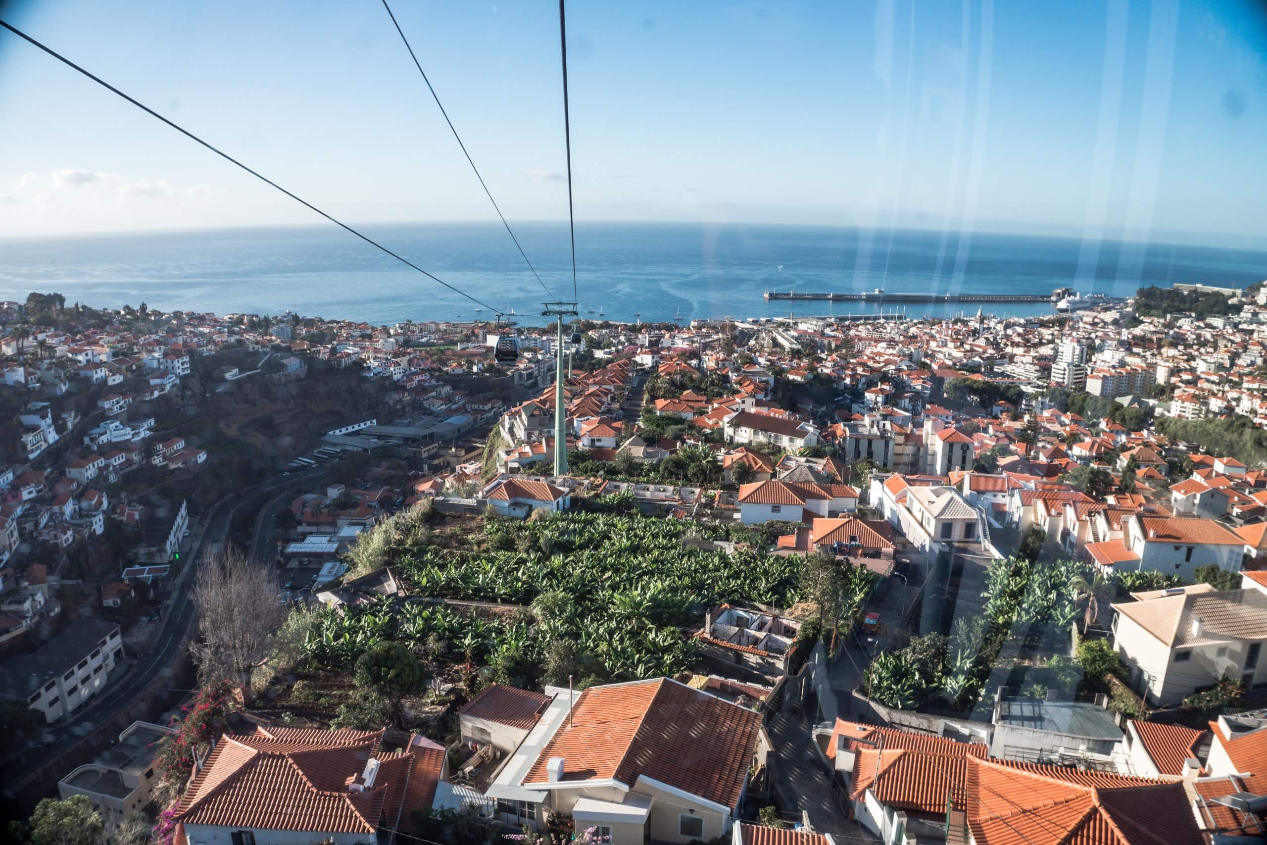 looking out over the rooftops of funchal from the cable car winding its way up to monte and with the sea in the background