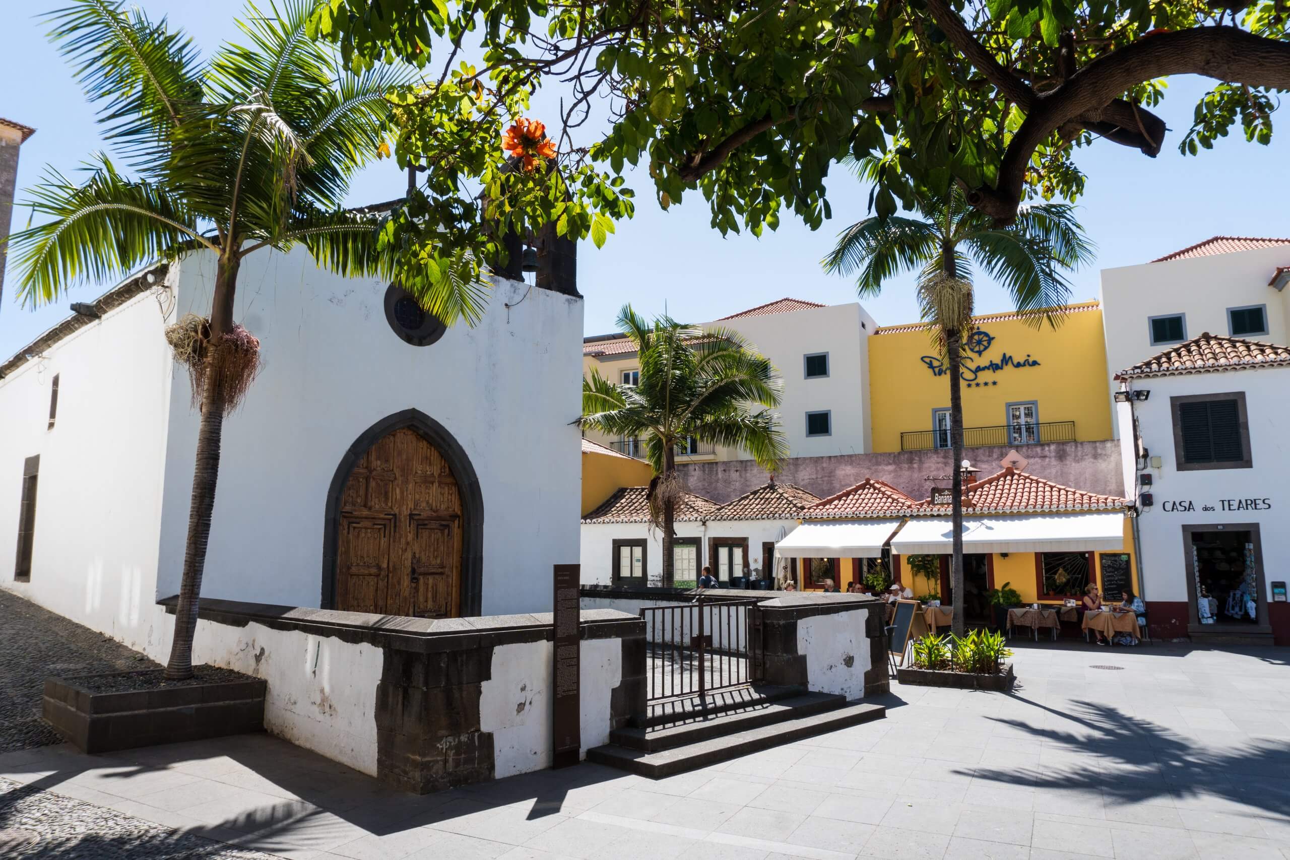 the small church with palm trees either side in the old town of funchal madeira