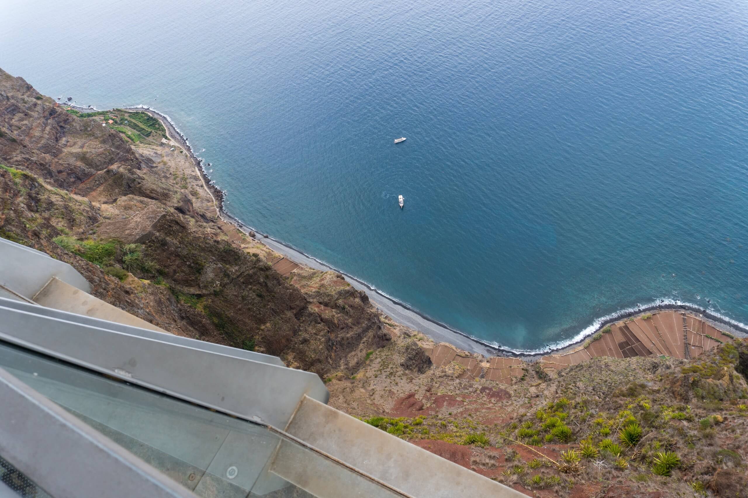 one of the best things to do in madeira showing the cabo girau skywalk and the view down the cliffs to the sea below