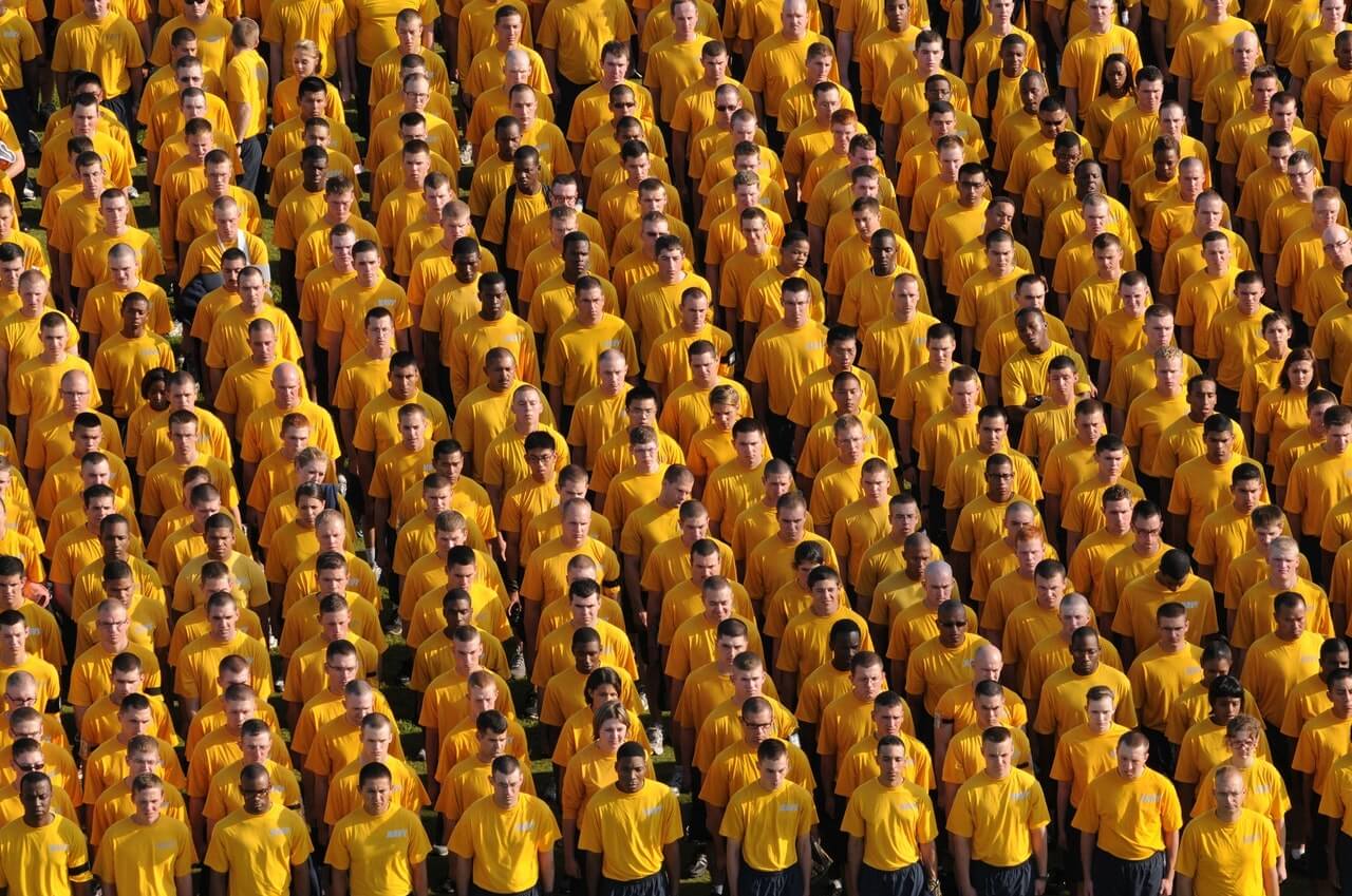 a crowd of people all dressed in yellow tshirts and black pants